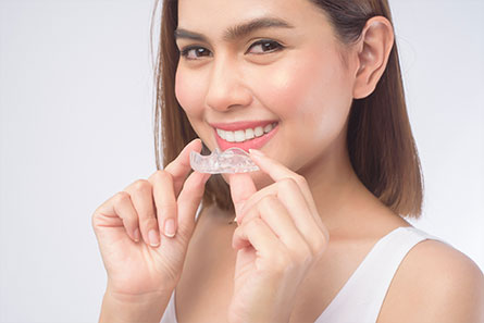 Smiling Woman Holding Invisalign
